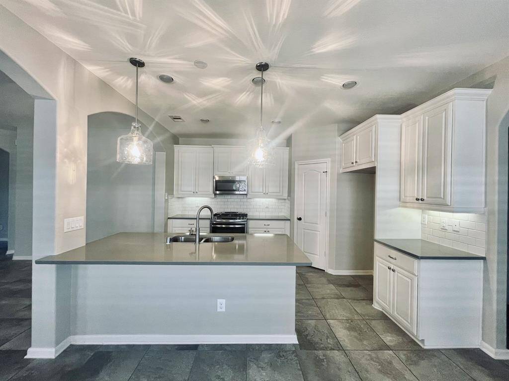 Fabulous clean and white kitchen everyone is looking for with Quartz counters and modern farmhouse style lighting.