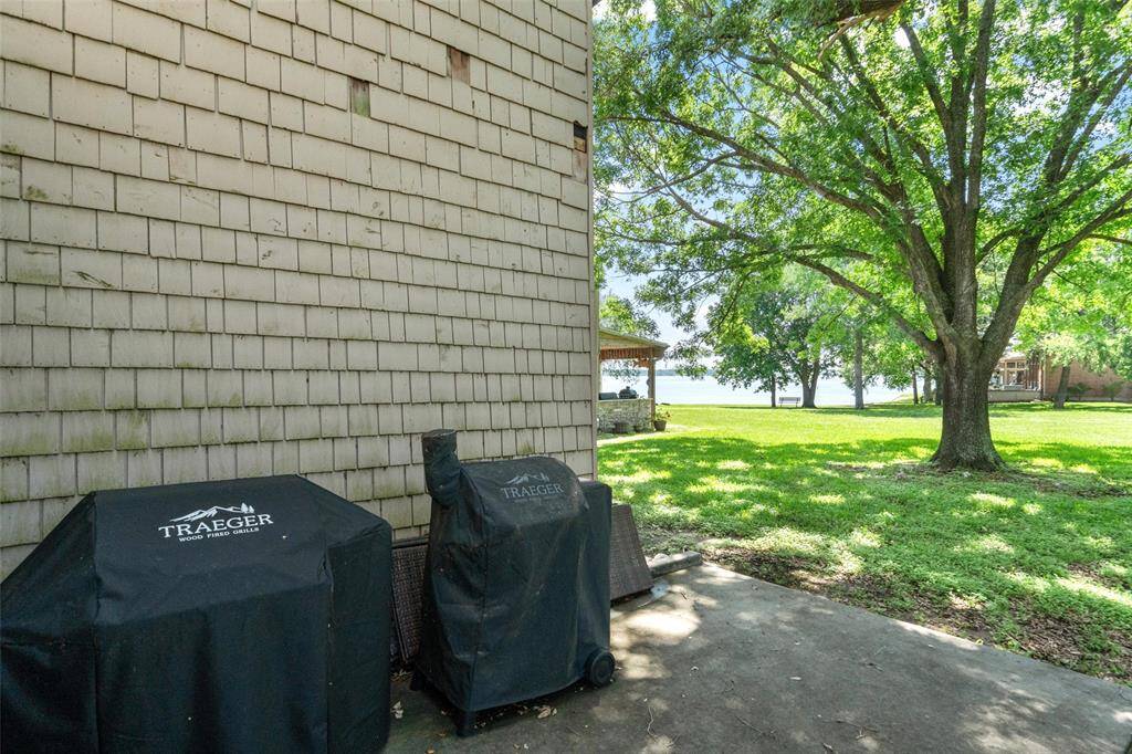 A glimpse of a tranquil waterfront is visible in the background, perfect for outdoor relaxation and entertaining.