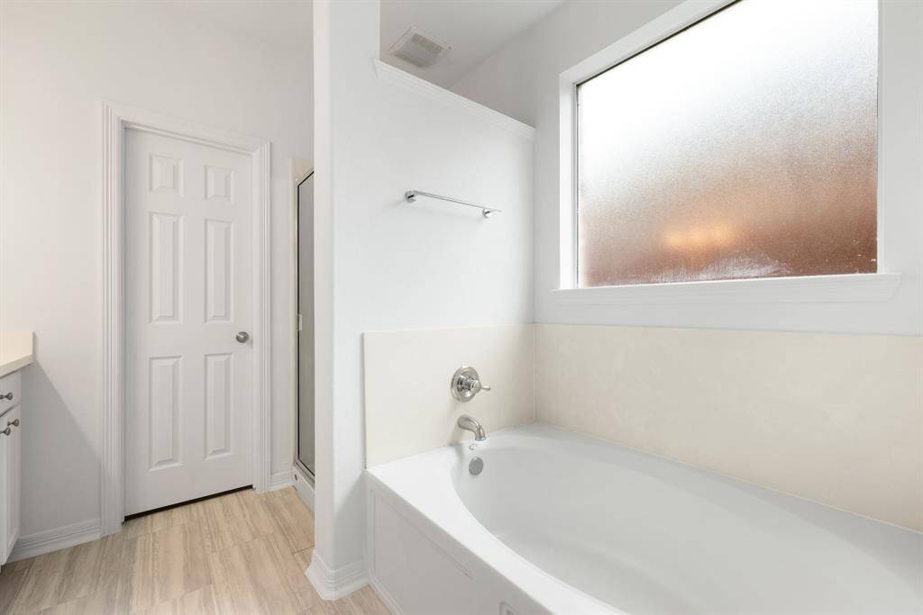 This additional view of the primary bath showcases a walk-in shower and a separate garden tub perfect for soaking after a long day.