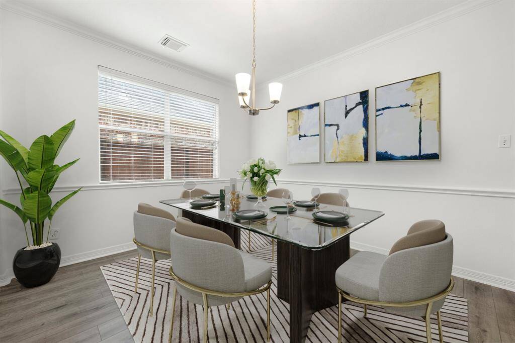 You and your guests will certainly dine in style in this amazing formal dining room! Featuring a gorgeous modern chandelier, large window with blinds, neutral paint, high ceilings, crown molding, chair rail and luxury vinyl plank flooring. Perfect space to entertain family and friends.