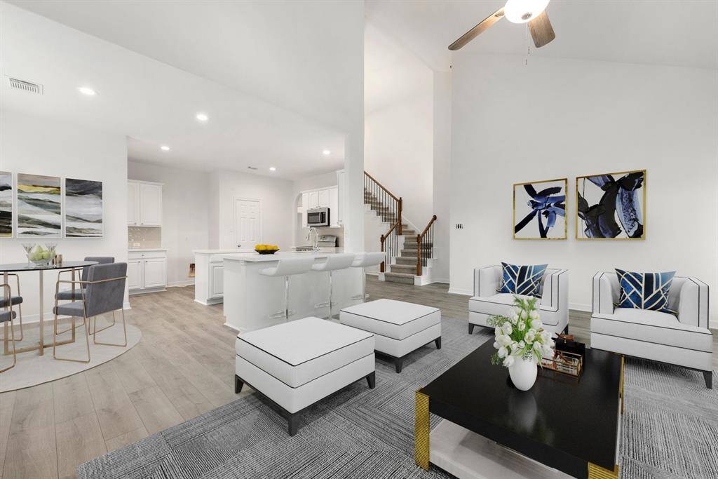 This living room is more like a GREAT room featuring a stunning fireplace with mantel detailing, fresh paint, soaring high ceiling, dark stained ceiling fan, and plenty of windows providing a lovely view of your backyard to keep an eye out on the kids or pets playing.