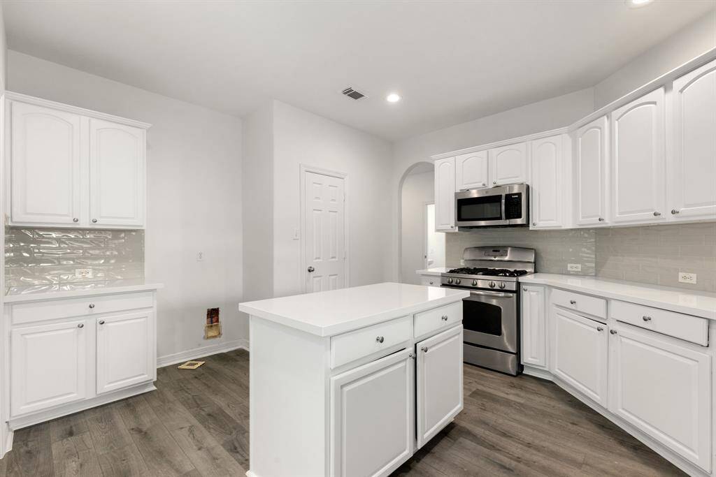 This kitchen is by far any chef’s dream! This spacious kitchen features large windows, high ceilings, white wood cabinets, Quartz countertops, SS appliances, modern tile backsplash, recessed lighting, extended counter space, Quartz kitchen island, space for breakfast bar and a pantry all overlooking your huge family room.