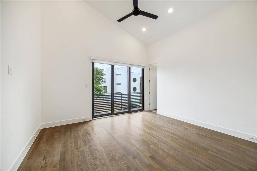 Upstairs game room with serious flex—vaulted ceilings, white oak hardwoods, and direct access to a private balcony make this space feel elevated and airy. Complete with a full bath, it’s perfect for movie nights, a home office, or guest overflow.