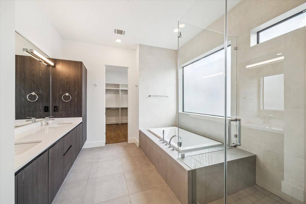 Clean, calming, and completely custom—this spa-inspired primary bath brings hotel luxury home with a deep soaking tub, frameless glass shower, and dual vanities.
