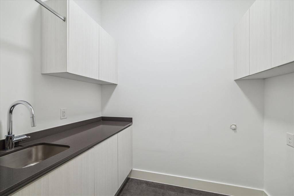Even laundry feels luxe with built-in storage, modern tile, and tucked-away functionality that keeps clutter out of sight and out of mind.
