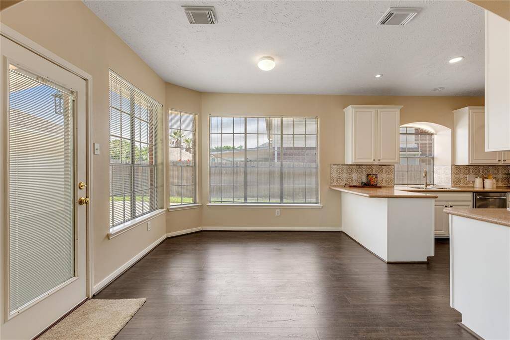 The breakfast room is surrounded by beautiful sunlight pouring in through  the abundence of windows