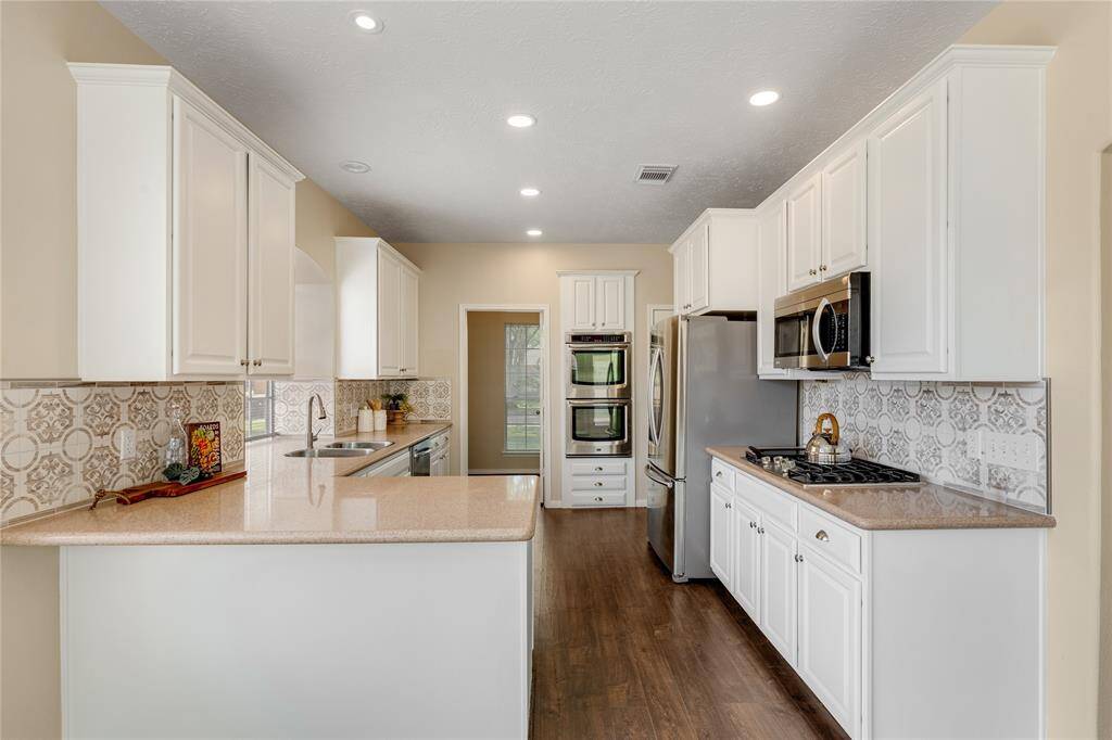 You'll love the silestone counters and the clean white cabinets.  Notice the double ovens!