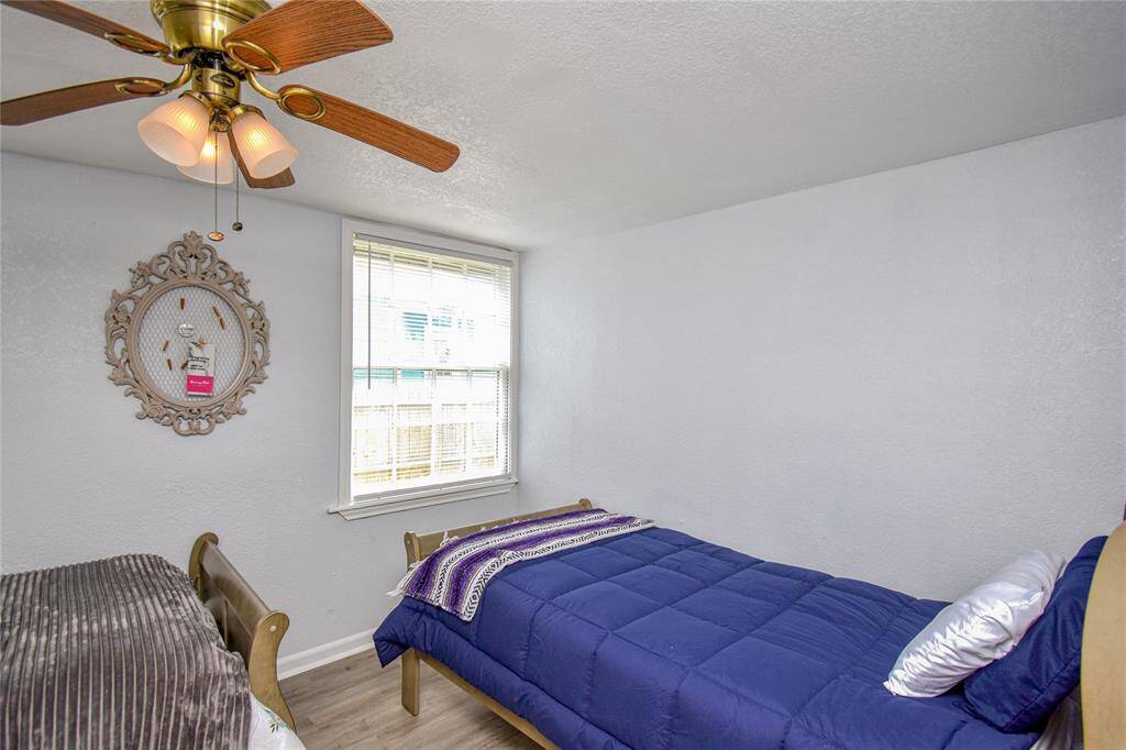 This bright bedroom showcases the home’s fresh paint and updated flooring- with plenty of space for rest, play, or productivity.