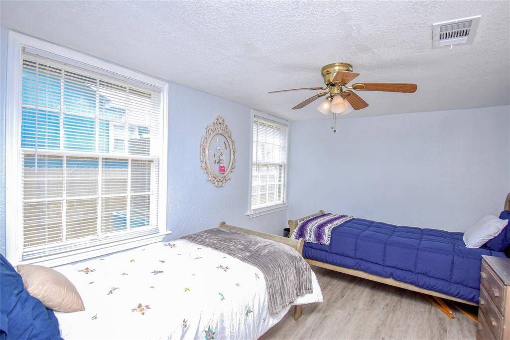 Featuring large windows that fill the space with natural light, this bedroom is both bright and inviting.