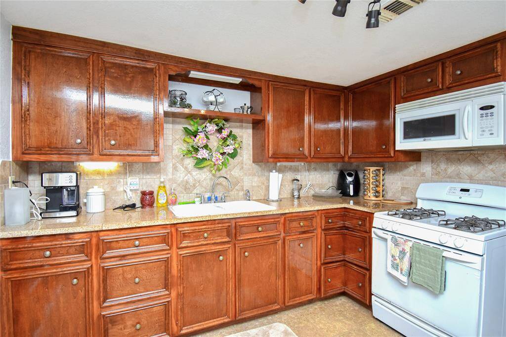 The kitchen is equipped with quality appliances, including a Maytag microwave, and GE gas range- designed for performance and durability.