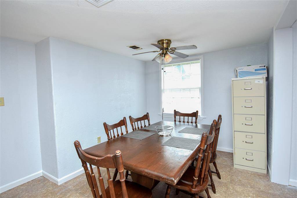 This inviting dining area boasts abundant natural light and a ceiling fan for added comfort- ideal for enjoying meals in a bright, breezy space.