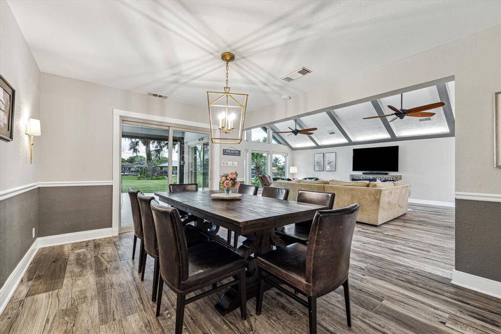Gather them around your table to honor old traditions and create the new. This elegant formal dining room offers designer paint, a stylish chandelier, wood-look tile flooring, and glass doors that open to the covered patio and gorgeous grounds.