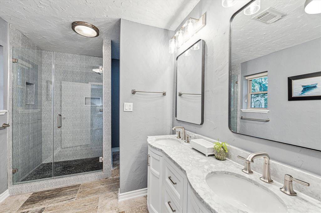 This beautifully updated ensuite has everything you need to prepare for the days adventures. Find a custom vanity with framed mirrors and updated vanity lights above, a spectacular walk-in shower, and a semi-private water closet.