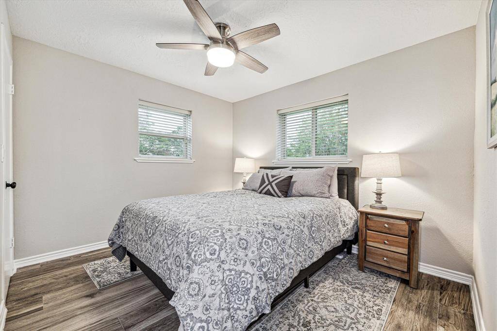 This spacious guest room offers fresh paint, a lit ceiling fan, a large closet, beautiful flooring, and easy access to a full bathroom.