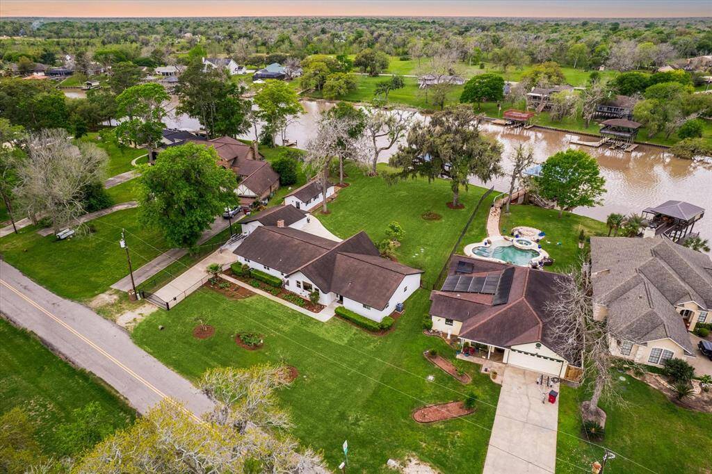 This water-front property offers over half an acre of land with a private driveway gate, a two car garage, covered outdoor areas, guest quarters, and a private boat dock and lift.