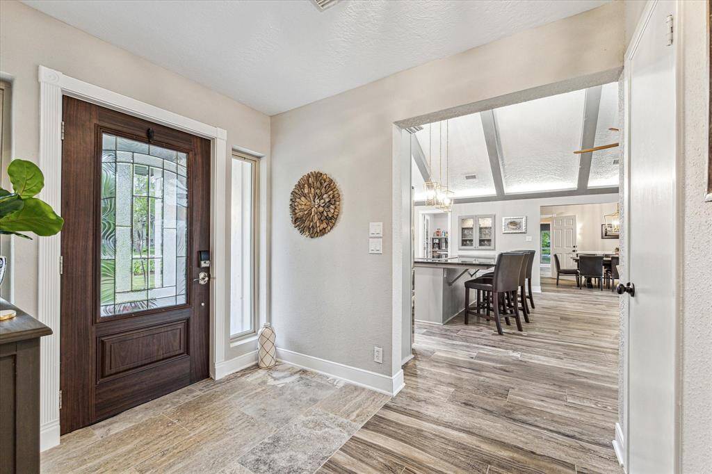 Step inside to find a home filled with amazing updates and beautiful design details throughout. Find fresh interior paint, wood-look tile flooring, chic lighting and fans, wood ceiling beams in a dramatic cathedral ceiling, oversized windows with picture-perfect views, a spectacular island kitchen, and so much more.