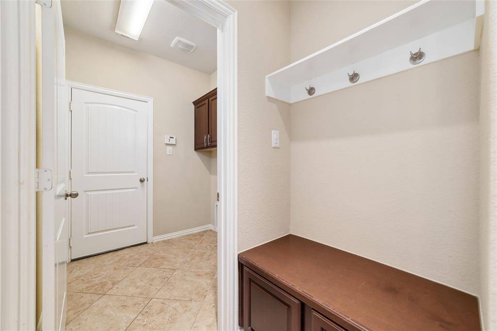 Mud room for hanging back packs purses and cabinets for shoes.