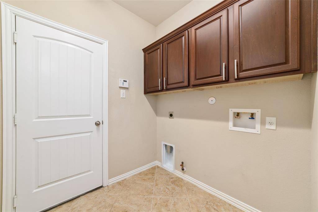 Large laundry room with cabinets.