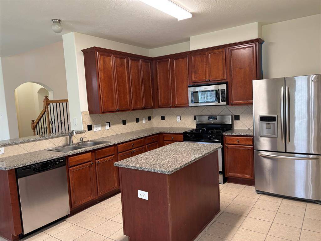 This room features clean, neutral walls and a cozy carpeted floor, with a ceiling light fixture and a window with blinds, providing natural light.