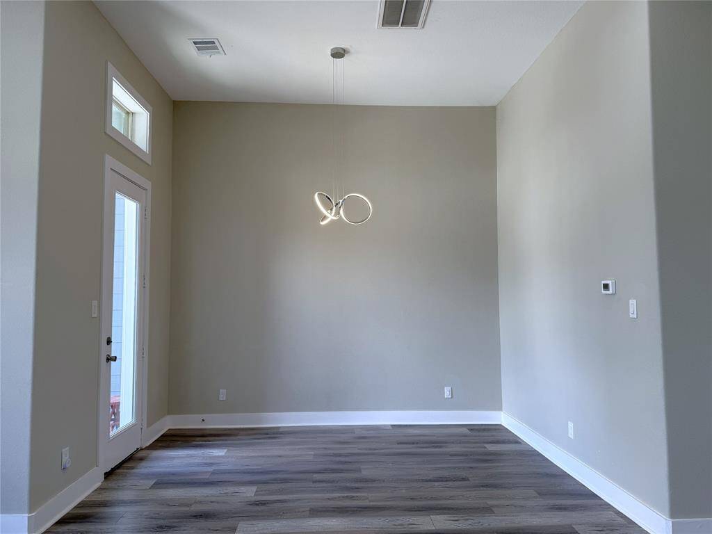 In the dining space, a glass paned door opens in from a balcony. Notice the modern light fixture.