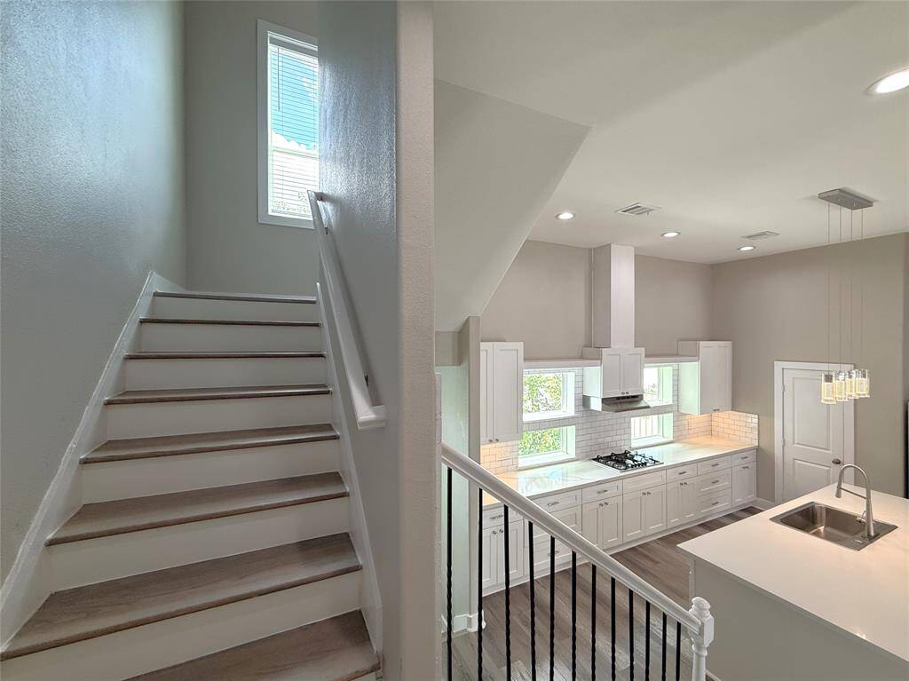 From the top of the stairs, natural light flows in from a window.
