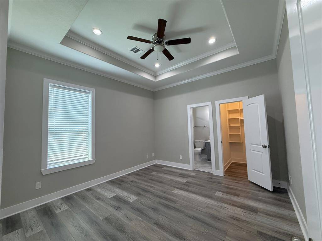 The 3rd floor secondary bedroom offers a coffered ceiling with fan, recessed lighting, walk-in closet & an en-suite bath.