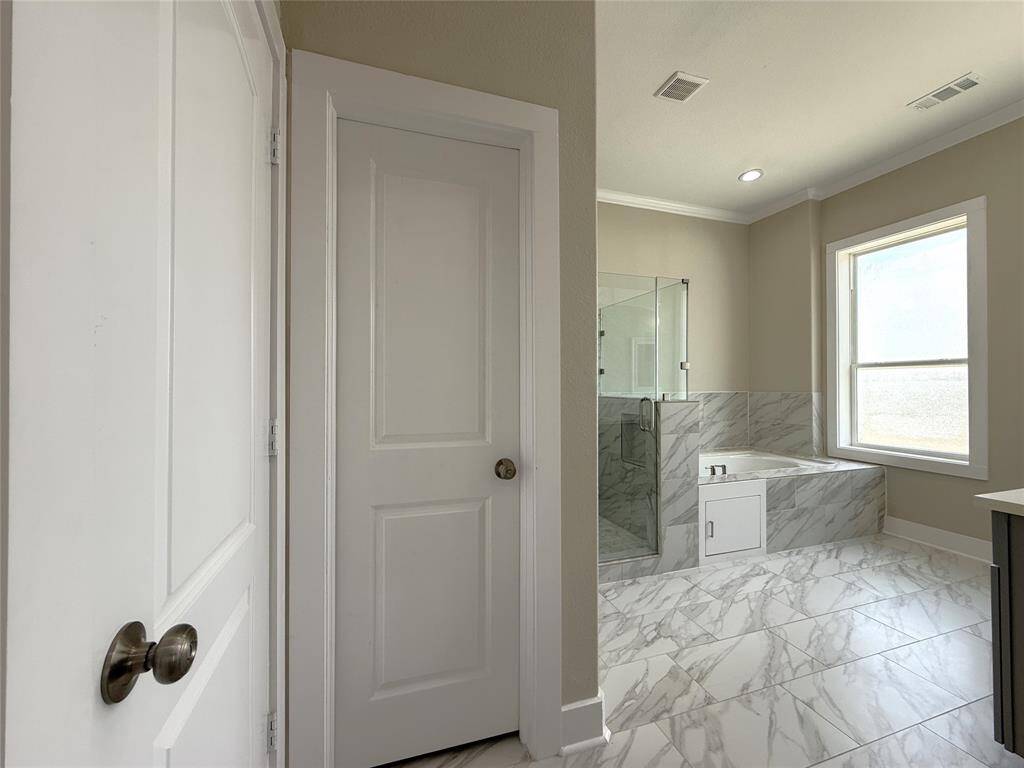 In the primary bathroom, beyond the door on the left is walk-in closet.