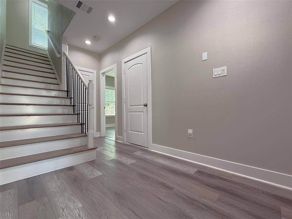 The entry foyer is nicely sized. Natural light flows in from a window at the top of the stairs.