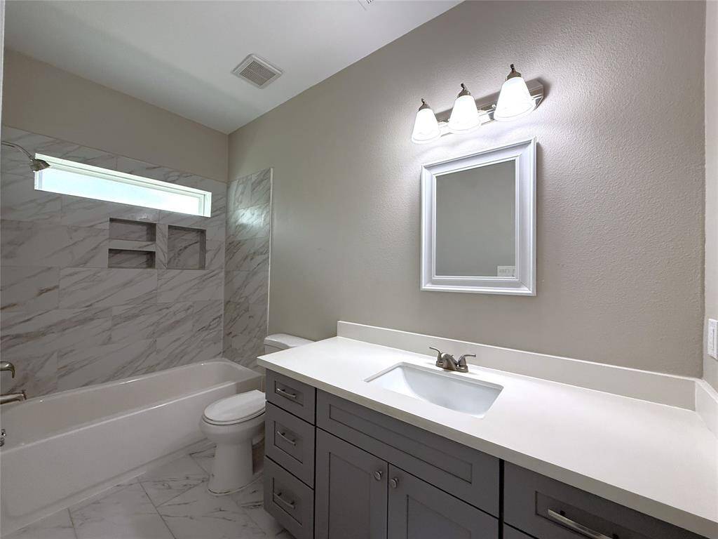 Tub/shower combo & a nicely sized vanity with storage space.