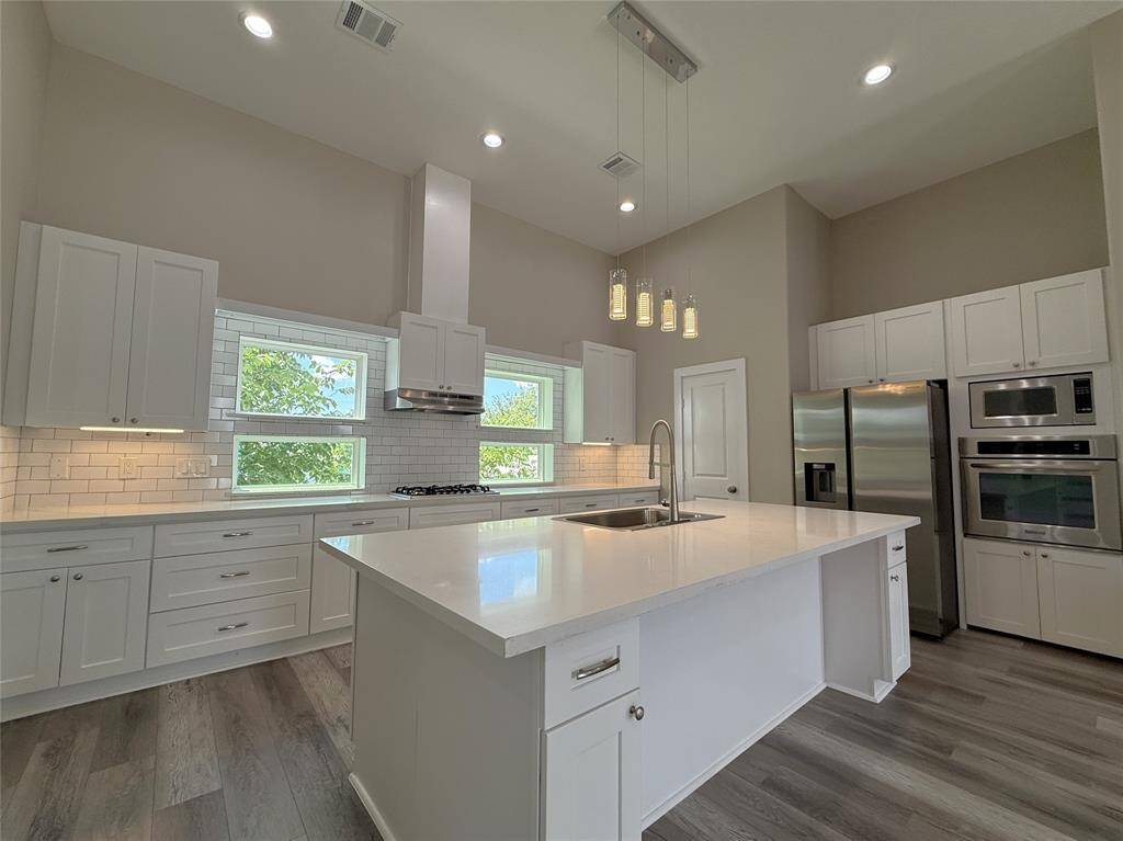 The breakfast bar can accommodate several bar stools. Notice the under-cabinet, recessed & pendant lighting.