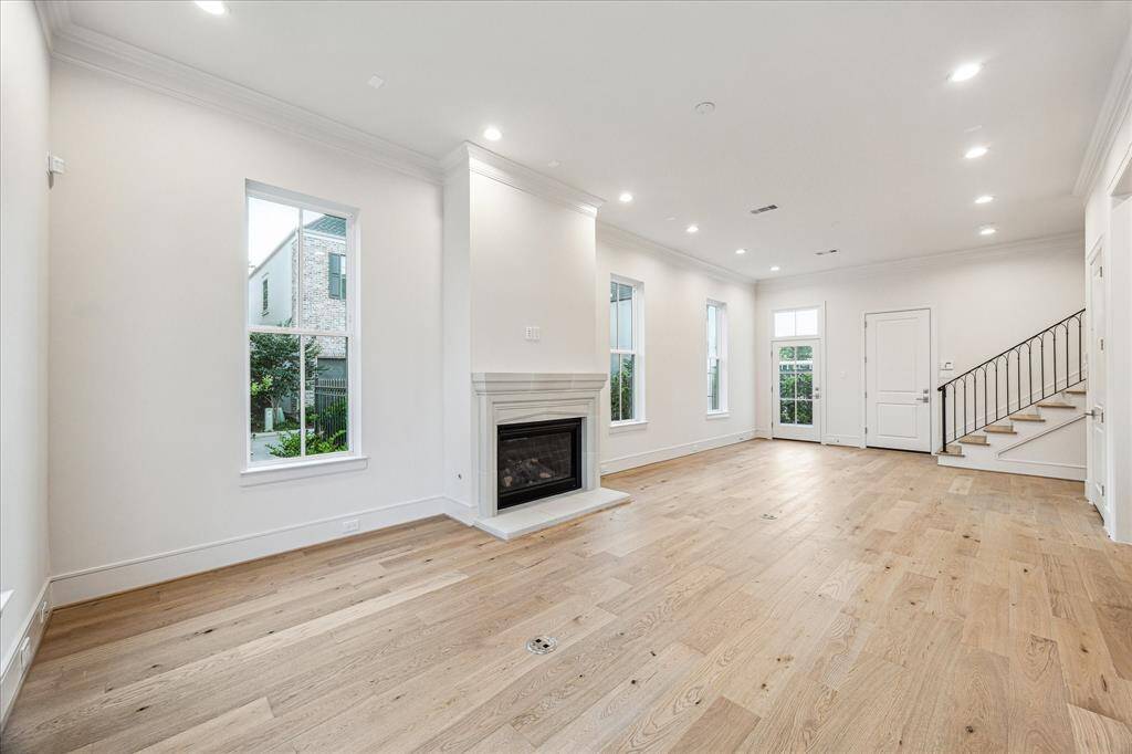 Living area with 11-foot ceilings, a lot of natural light, and a gas log fireplace.