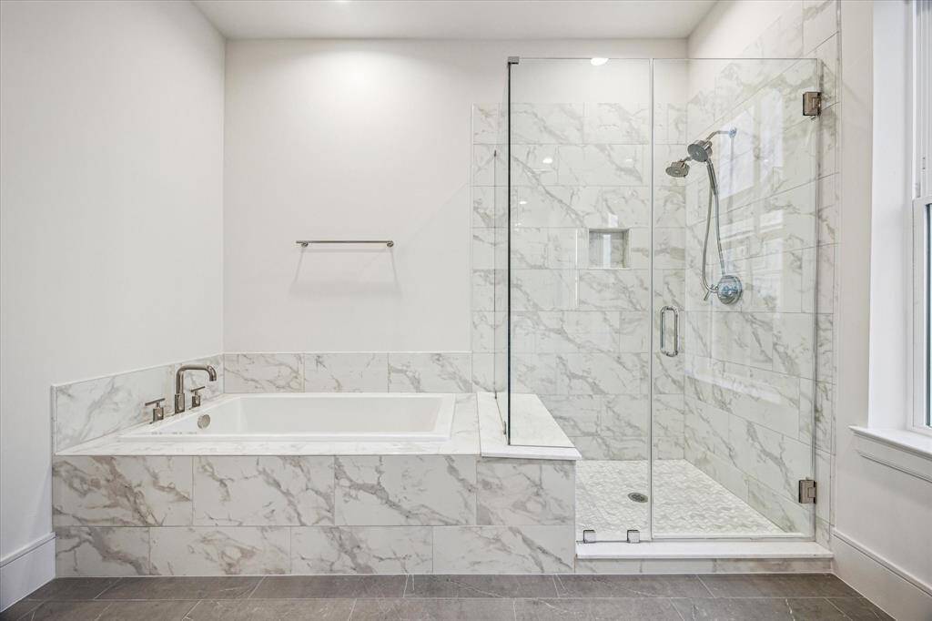 Primary bath and shower with marble mosaic flooring.