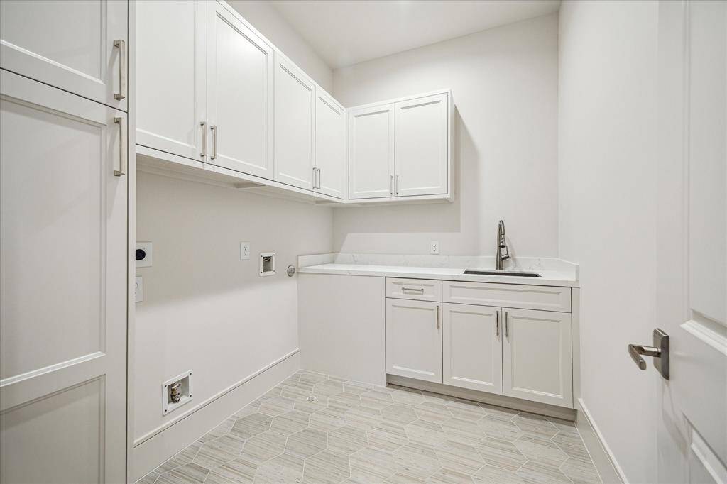 Extra-large utility room with built in cabinets, quartz countertop and sink.