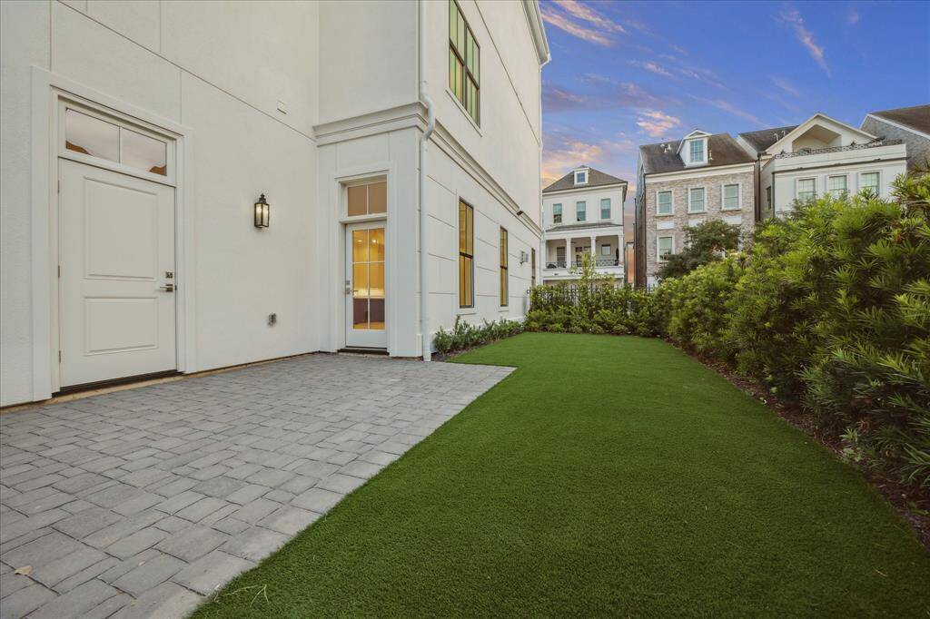 Spacious side yard fully landscaped with iron fence.  Notice the door that leads to the main living area.