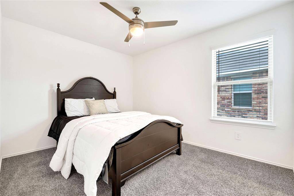Secondary bedroom with plush carpet, blinds, and upgraded ceiling fan