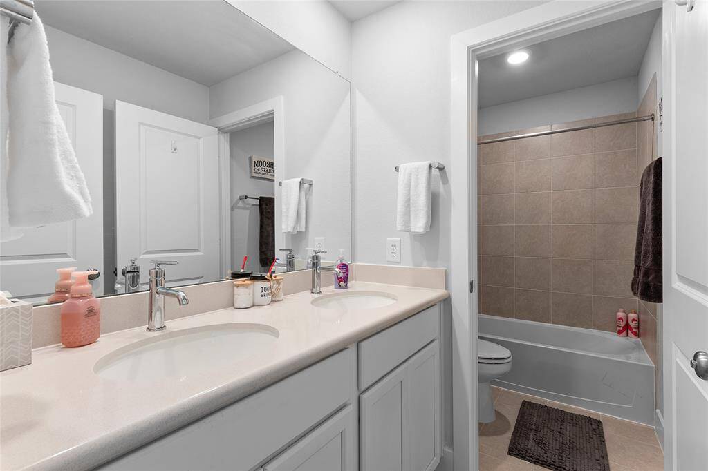 Hallway Full bathroom with double sinks.