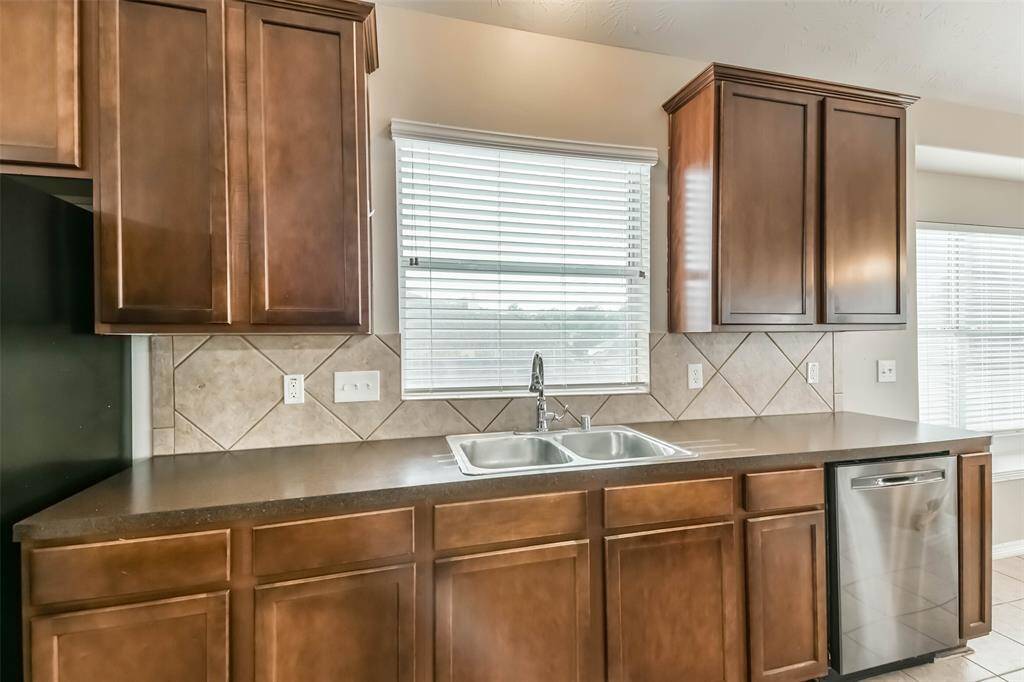 Functional kitchen with gas stove, oven, and included refrigerator.