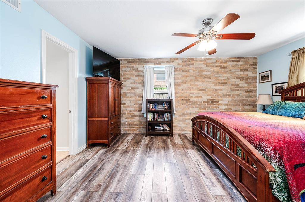 Primary bedroom with brick accent wall.