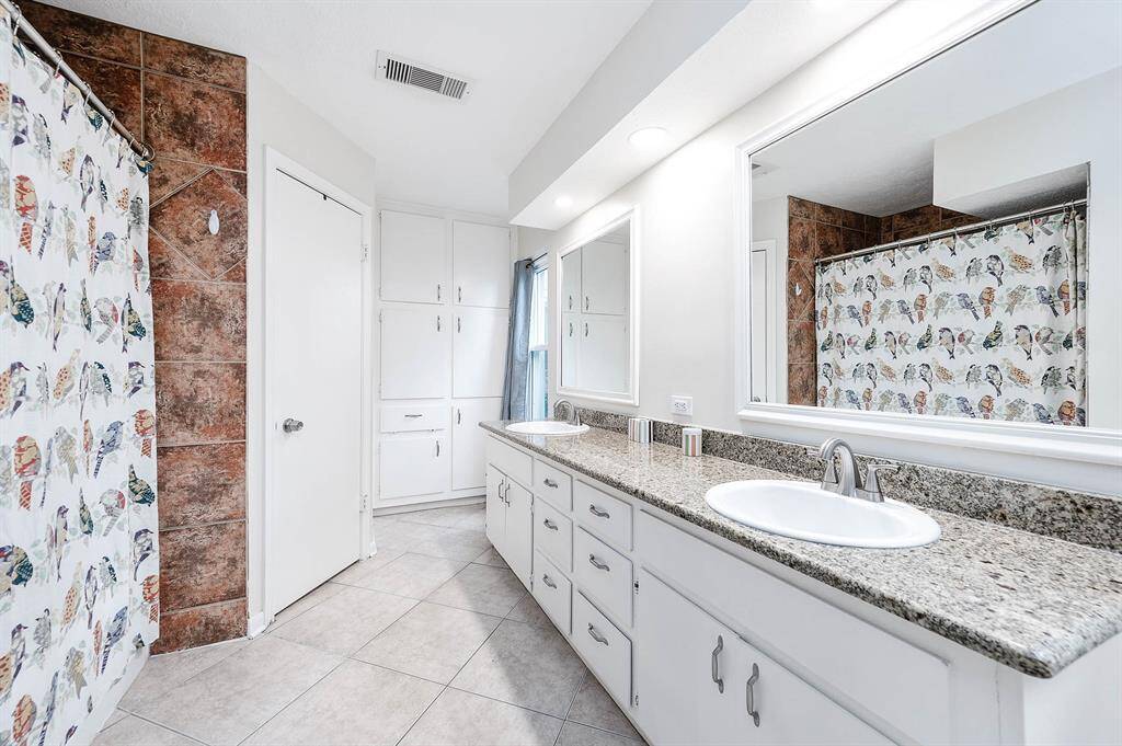 Light and bright primary bathroom with double sinks and plenty of storage space!