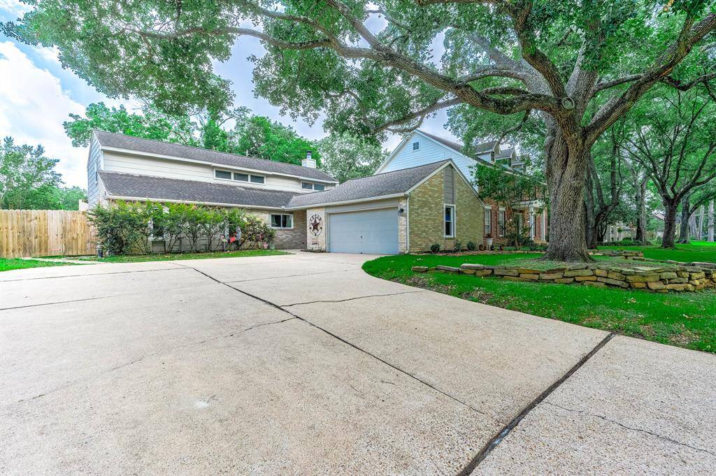 Home features a double wide and long drive way with covered front porch and mature trees.
