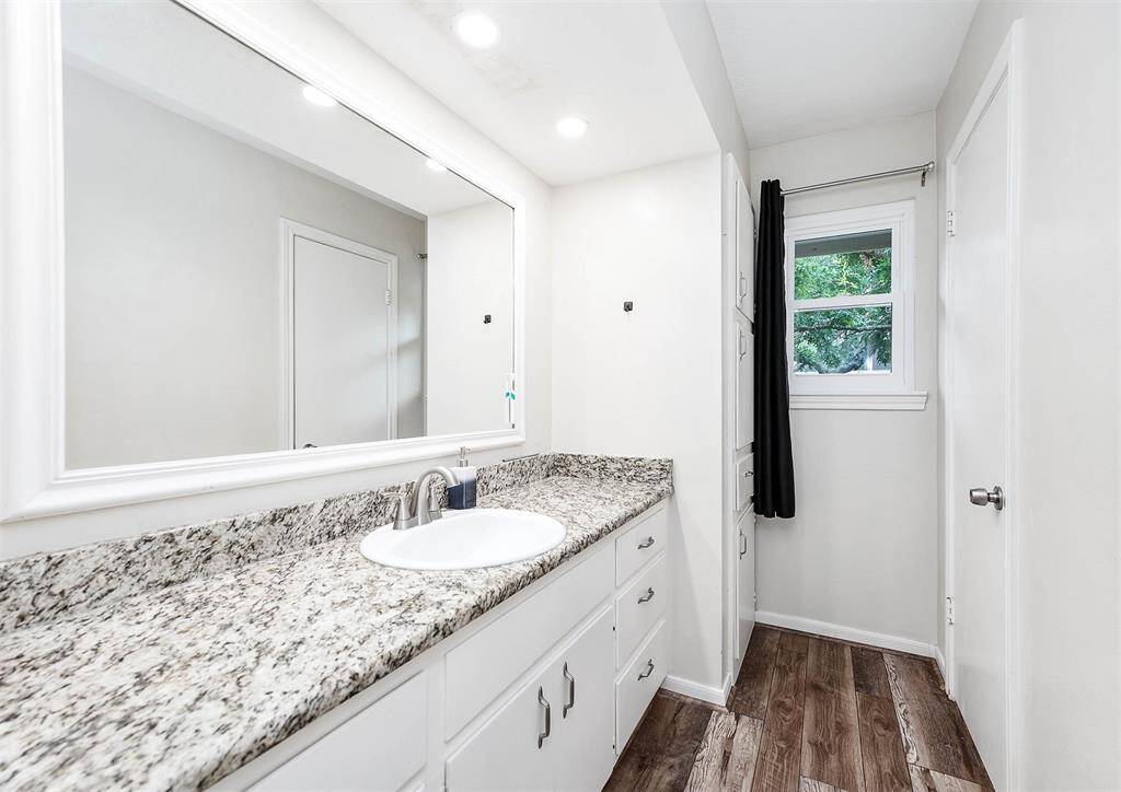 Secondary bathroom with granite countertops and new flooring.