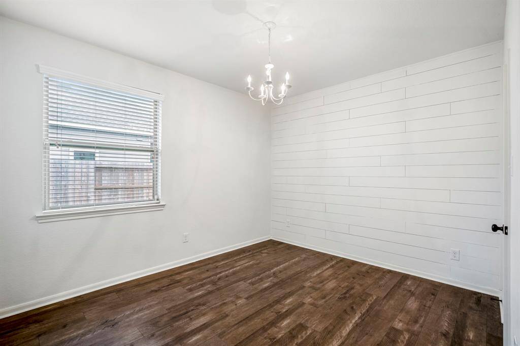 Inviting downstairs bedroom featuring a stylish accent wall, ready for personalization!