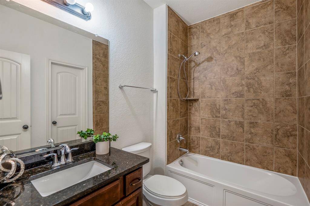 Conveniently located downstairs, this stylish second bathroom features modern fixtures and elegant tilework.