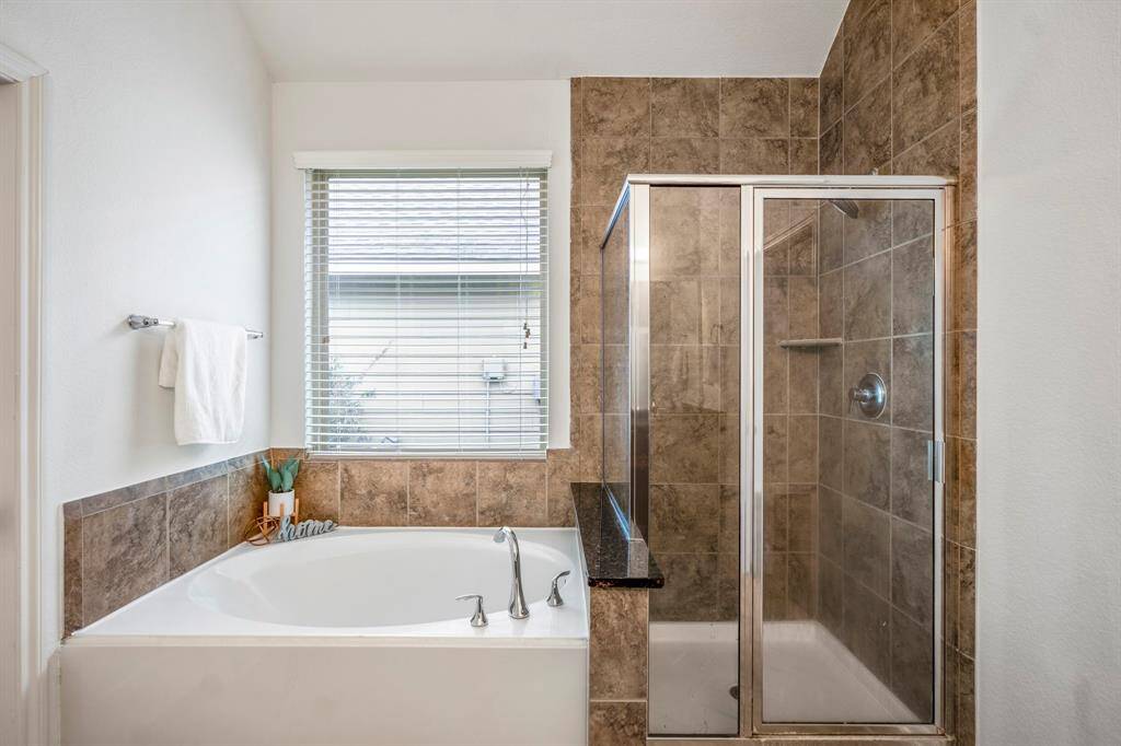 Indulge in the luxury of a separate tub and shower, enhanced by abundant natural light from the window.