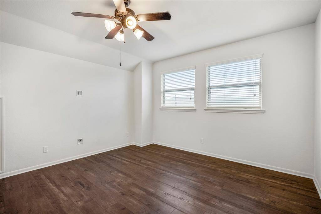 Spacious game room with abundant natural light, visible from the hallway.