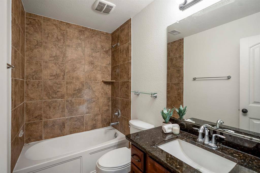 Modern shared bathroom on the upper level, featuring elegant tile and a sleek vanity.