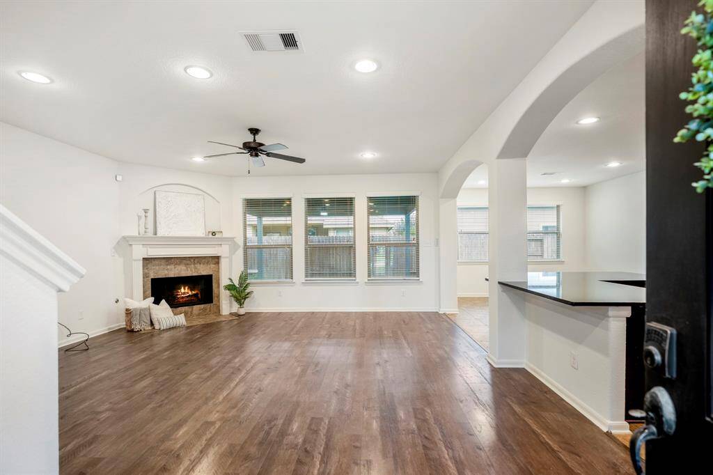 Welcome home to a spacious living area with elegant hardwood floors and a cozy fireplace, perfect for relaxation and entertaining.