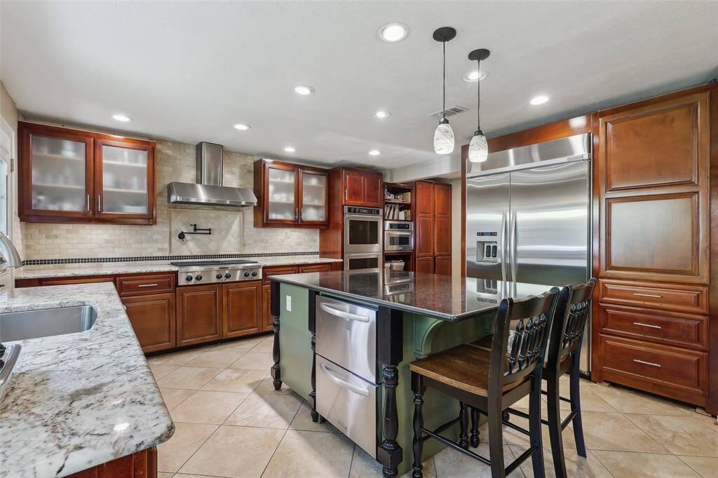 Gourmet kitchen with sleek granite countertops, a spacious island, and upgraded stainless steel appliances, perfect for preparing meals and entertaining in style
