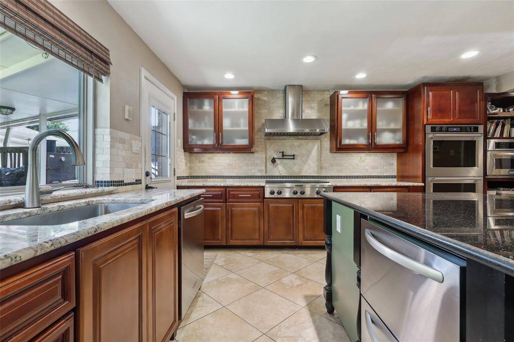Kitchen features a large farmhouse sink beneath a generous window, offering a beautiful view of the backyard while providing the perfect space for meal prep and daily tasks. Island offering extra mini fridge for extra storage