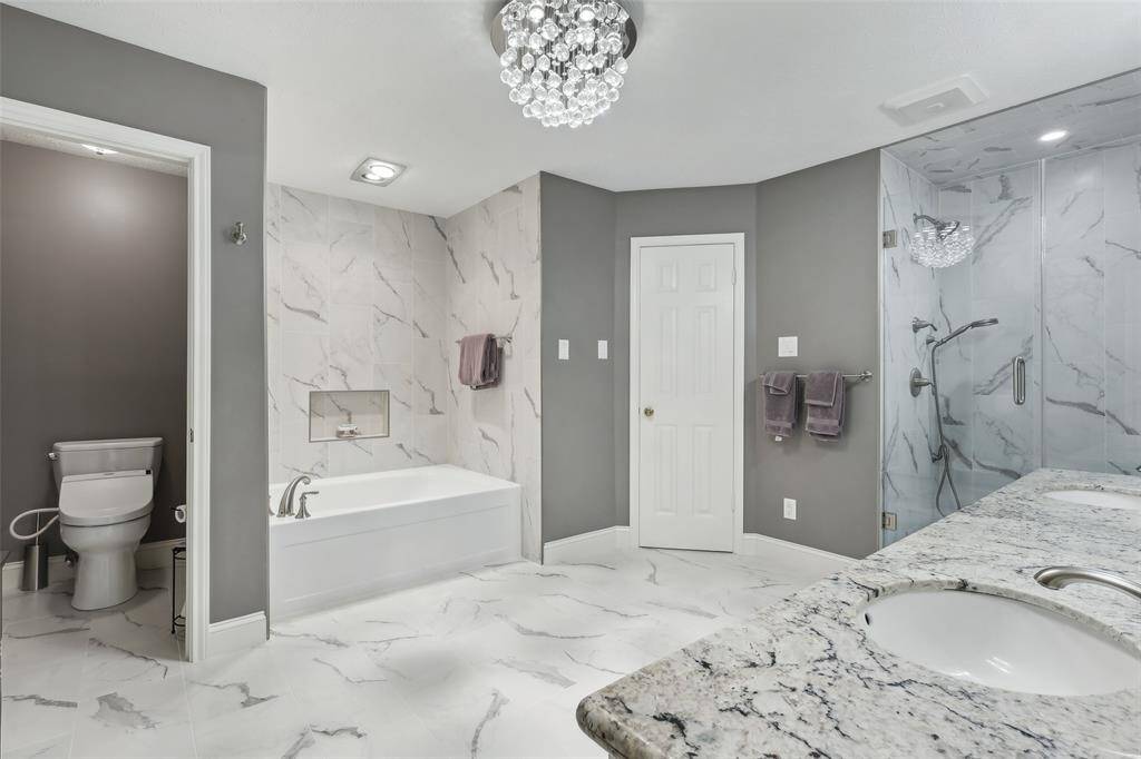 Beautifully updated primary bath featuring numerous upgrades, including elegant tile work, fresh paint, and stylish fixtures, creating a spa-like atmosphere
